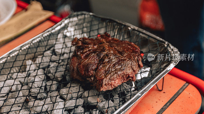 BBQ party，户外烧烤活动。火与肉摄影。在木炭烤架上烤肉片，烧烤牛排的特写照片